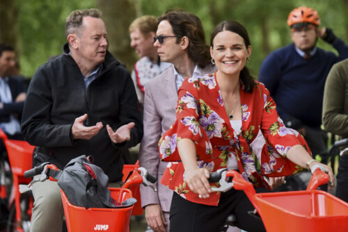Riders chatting on red Jump hire bikes before the 2019 Parliamentary Bike Ride