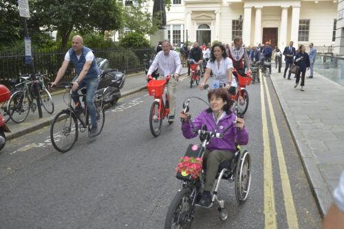 Riders, including a hand-cyclist, setting off down a Westminster street on the 2019 Parliamentary Bike Ride