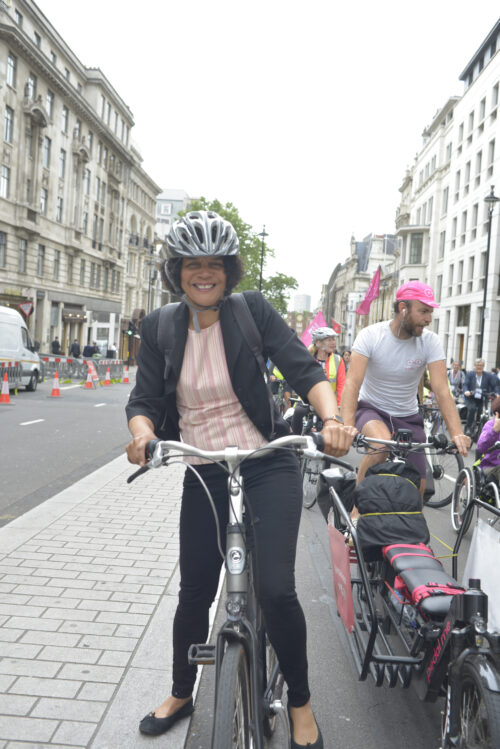 A woman in a helmet standing with her bike on a London pavement during the 2019 Parliamentary Bike Ride
