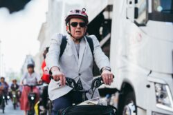 A woman in a helmet and sunglasses riding past a lorry on the 2023 Parliamentary Bike Ride
