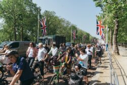 A crowd of riders with their bikes lined up along The Mall under Union flags